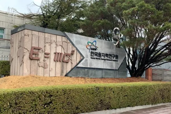 Panneau d'entrée de l'Institut coréen de recherche sur l'énergie atomique (KAERI) représentant la formule E=mc² d'Einstein dans un cadre naturel en plein air