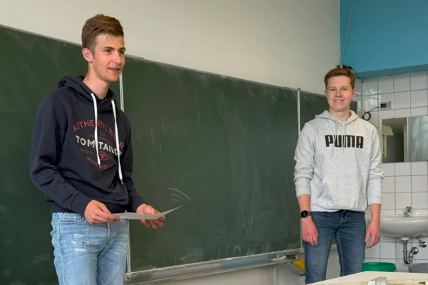 Двама ученици се представят на подиума в класната стая по време на NETZSCH Science Cup, представяйки творчески своите идеи за проекти.