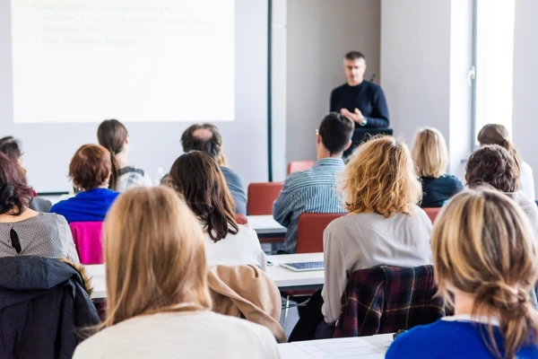 Durante un seminario sull'analisi termica, un docente presenta a un pubblico coinvolto le tecniche di spettroscopia infrarossa con trasformata di Fourier.