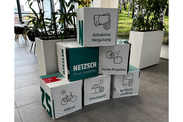 NETZSCH изложение в офиса, представящо различни ползи за служителите, включително атрактивно възнаграждение, отпуск, обучение и възможности за проекти.